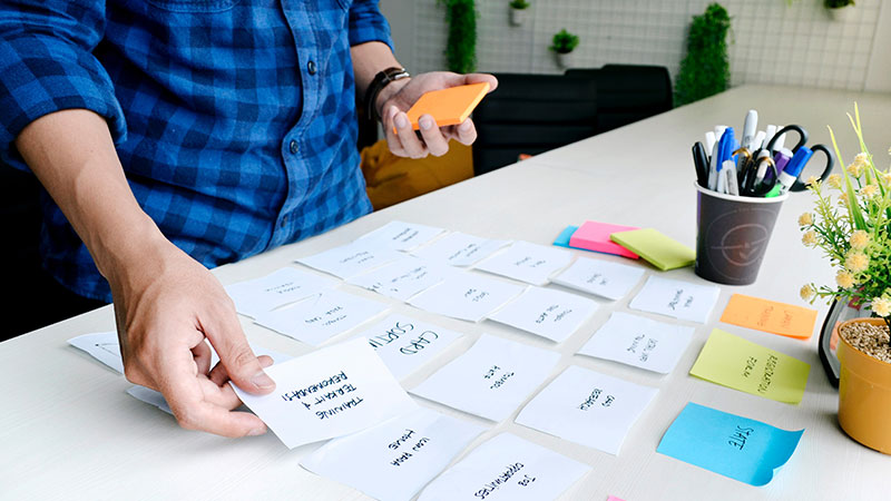 A team member arranging planning notes on a table