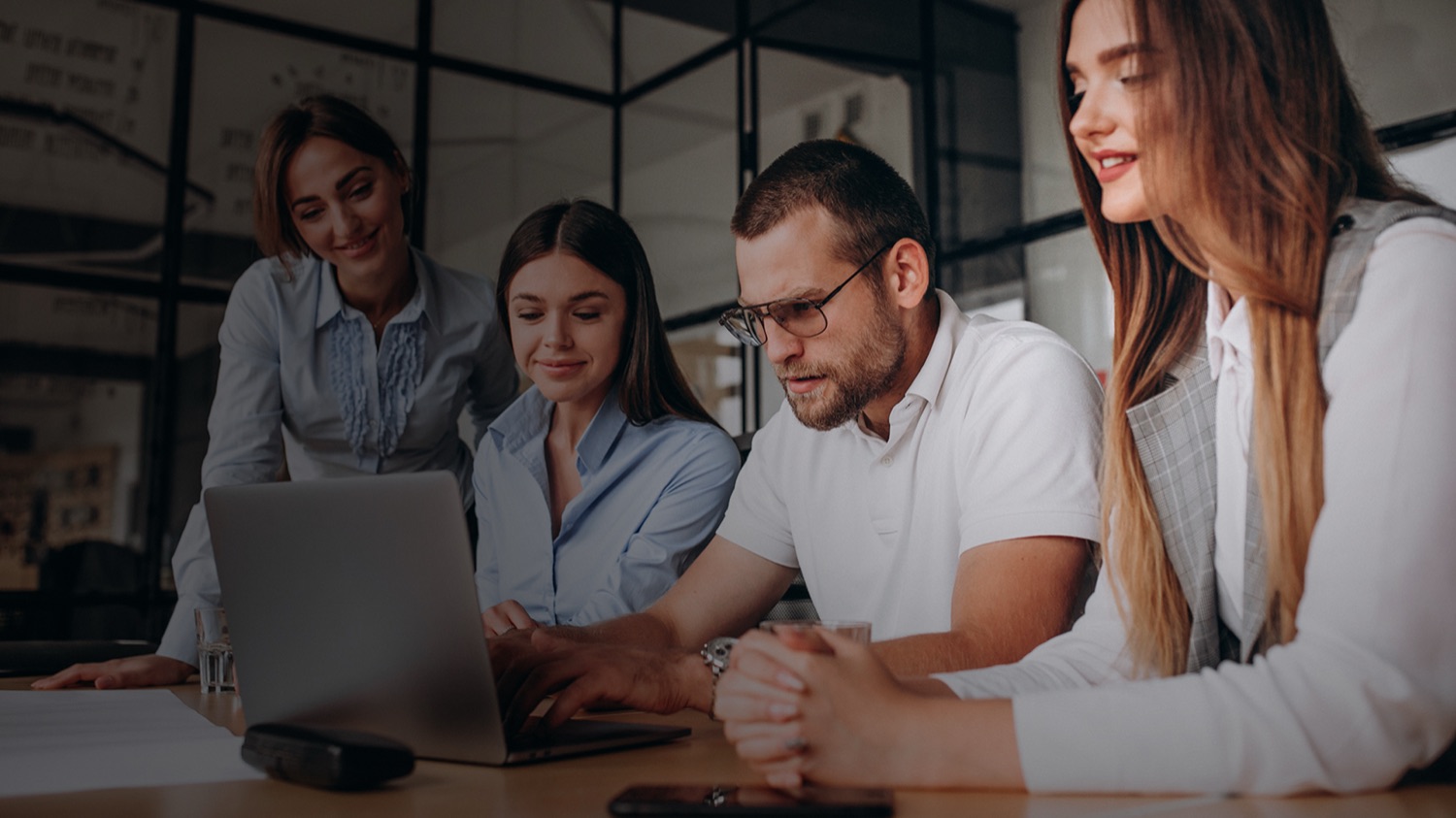 A group of colleagues learning together at a laptop